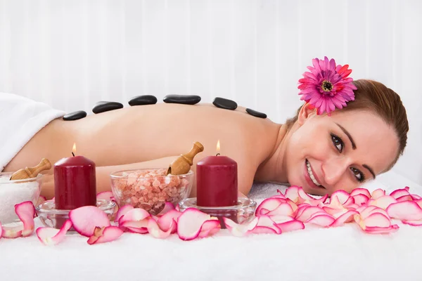 Mujer feliz recibiendo terapia de piedra caliente — Foto de Stock