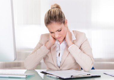 Young Businesswoman Suffering From Neck Pain At Office