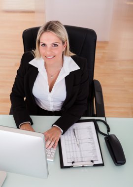 Bilgisayar kullanan mutlu iş kadını