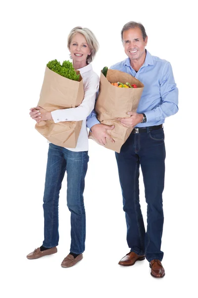 Couple d'âge mûr tenant l'épicerie — Photo