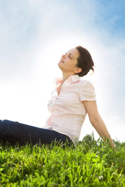 Молода жінка розслабляється травою — стокове фото