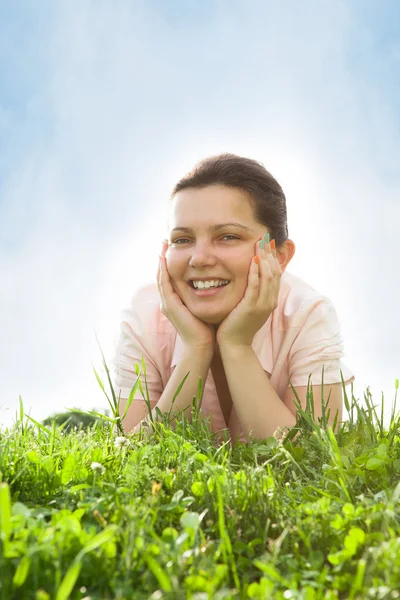 Ung kvinna avkopplande i gräsmark — Stockfoto