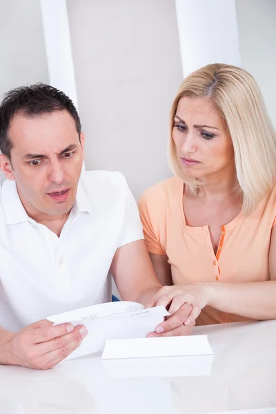 Shocked couple looking at bill — Stock Photo, Image