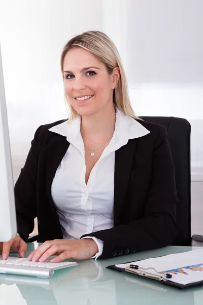 Gelukkig zakenvrouw met behulp van computer — Stockfoto