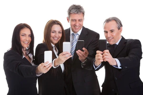 Mensen uit het bedrijfsleven kijken naar mobiele telefoons — Stockfoto