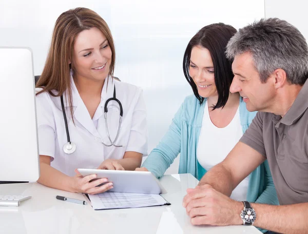 Médico mostrando tableta digital al paciente — Foto de Stock