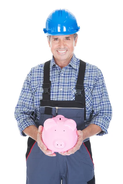 Портрет рабочего, владеющего Piggybank — стоковое фото