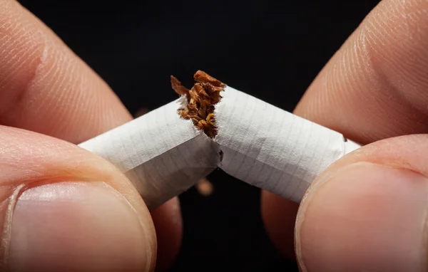 Rompiendo cigarrillos a mano — Foto de Stock