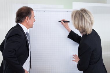 işadamı işkadını flipchart üzerinde yazma bakarak