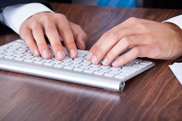 Biznesmen wpisujący na klawiaturze komputera — Zdjęcie stockowe
