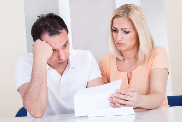 Shocked couple looking at bill — Stock Photo, Image