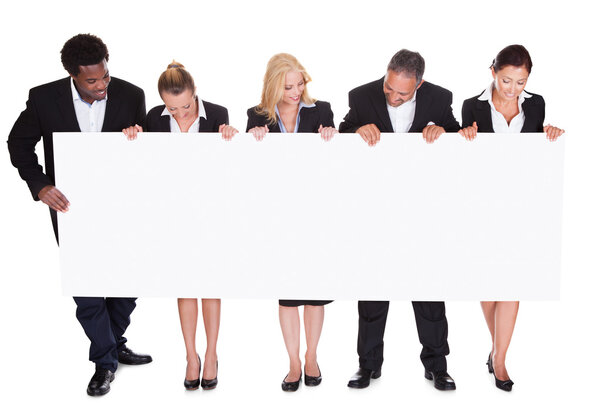 Группа бизнесменов, держащих плакаты
