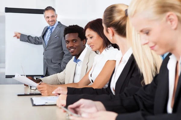Företagsledare tar anteckningar under ett möte — Stockfoto