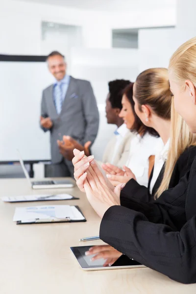 Geschäftsleute klatschen für einen Mann im Meeting — Stockfoto