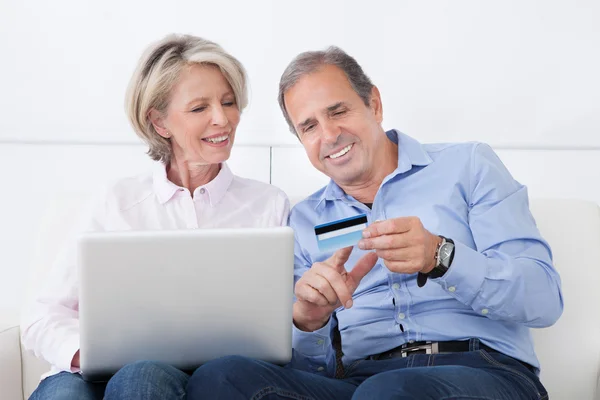 Glückliches reifes Paar beim Einkaufen auf dem Laptop — Stockfoto