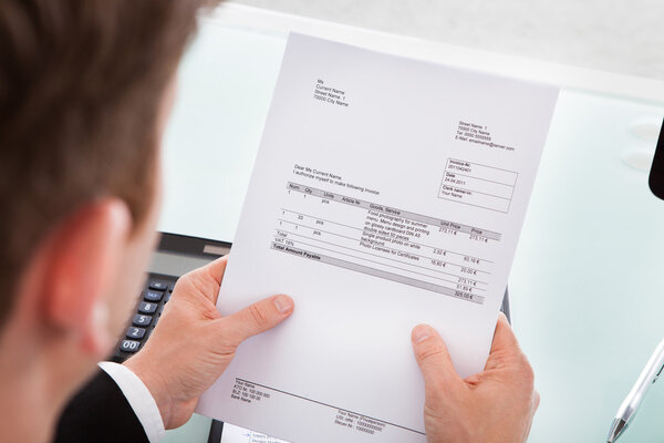 Businessman holding invoice paper