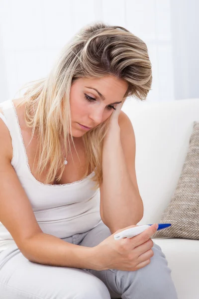 Worried woman checking pregnancy test — Stock Photo, Image