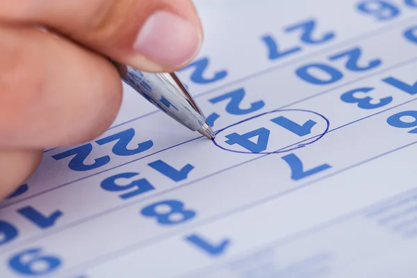 Primo piano dell'uomo che segna sul calendario Fotografia Stock