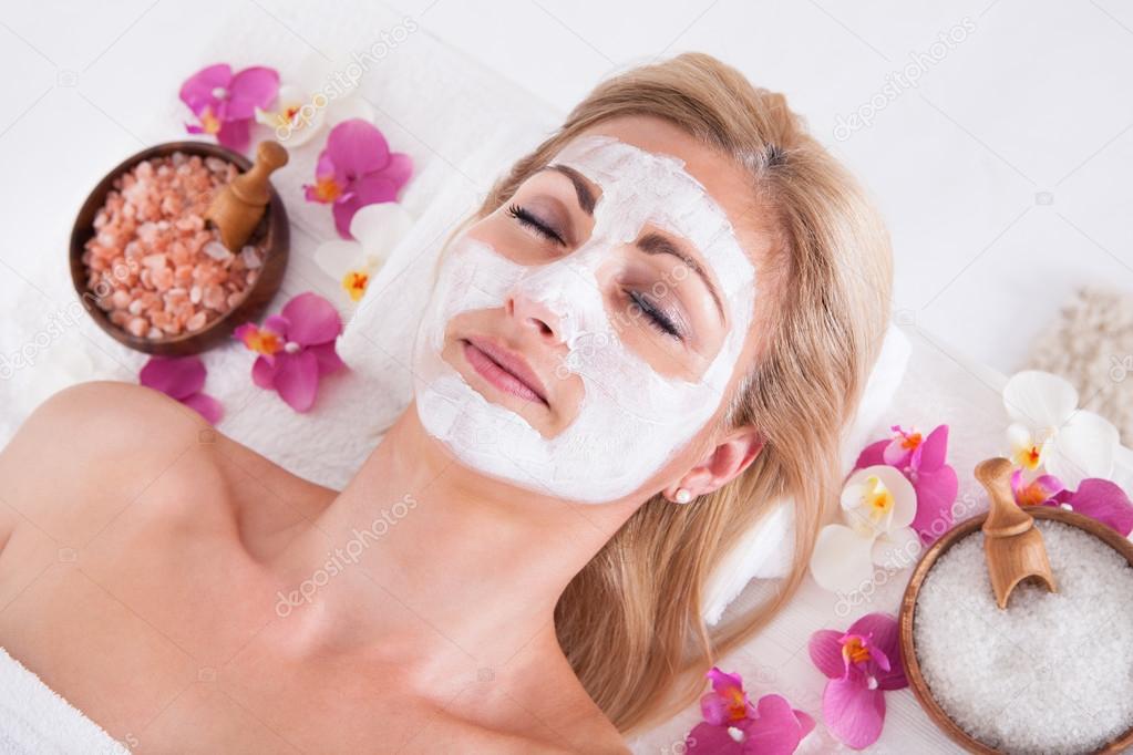 Cosmetician Applying Facial Mask On Face Of Woman
