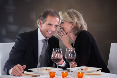 Neşeli kadın adamın kulağına fısıldayan