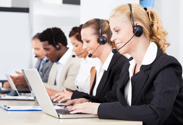 Hermosa mujer joven hablando en auriculares — Foto de Stock