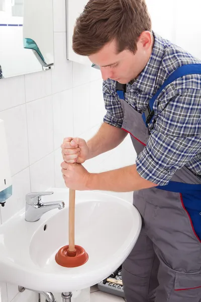 Portrait of male plumber pressing plunger — Stock Photo, Image