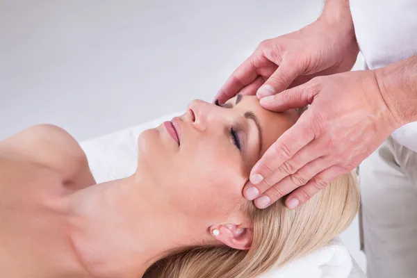 Kvinna med ansiktsmassage i Spa — Stockfoto