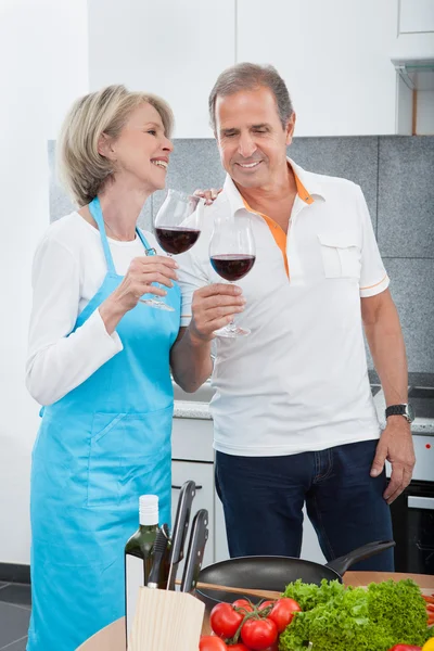 Happy Mature Drinking Wine In Kitchen — Stock Photo, Image