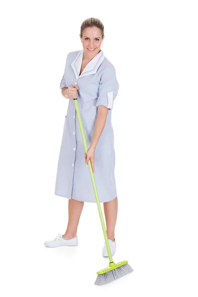 Jovem empregada doméstica limpeza chão com esfregão — Fotografia de Stock
