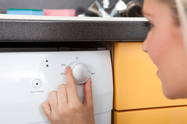 食器洗い機の設定を調整する女性 — ストック写真