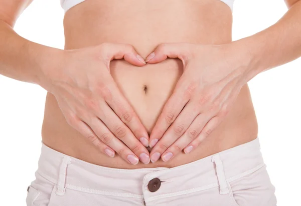 Woman's hands forming heart shape on belly — Stock Photo, Image