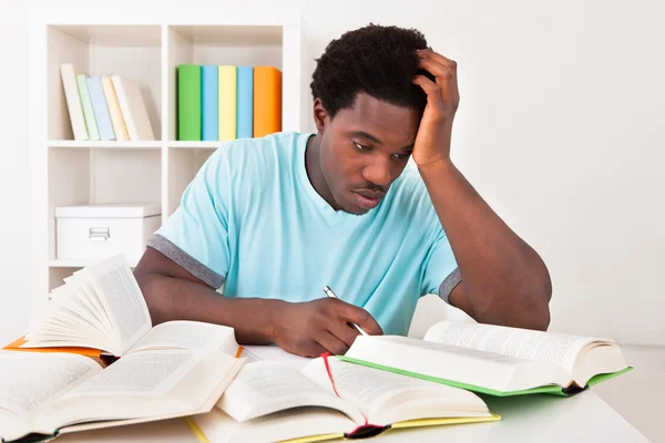 Bezorgd jonge Afrikaanse man studeren — Stockfoto