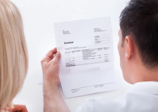 Portrait of couple looking at bill — Stock Photo, Image