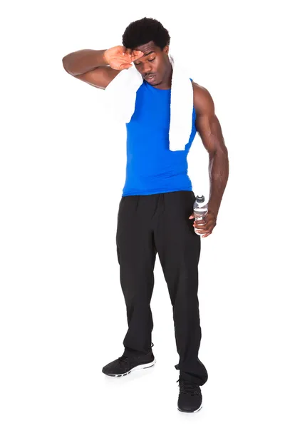Atleta africano sosteniendo botella de agua en la mano —  Fotos de Stock