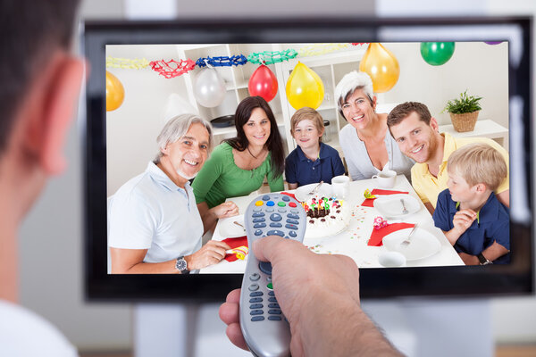 Man changing television channel through remote