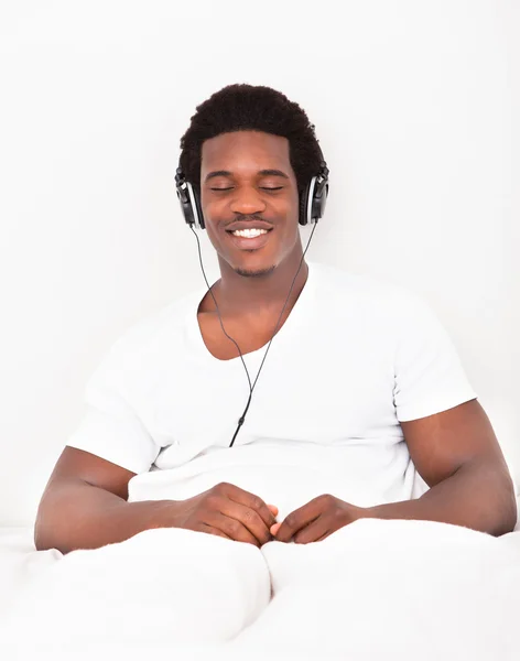 Junger Mann hört über Kopfhörer zu — Stockfoto