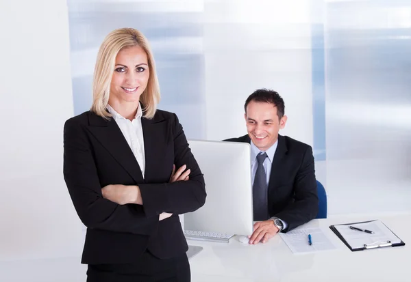 Femme d'affaires debout devant son collègue en utilisant l'ordinateur — Photo