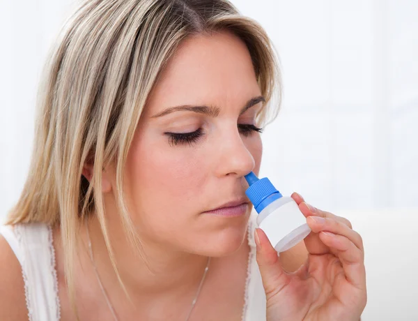 Mujer usando spray nasal — Foto de Stock