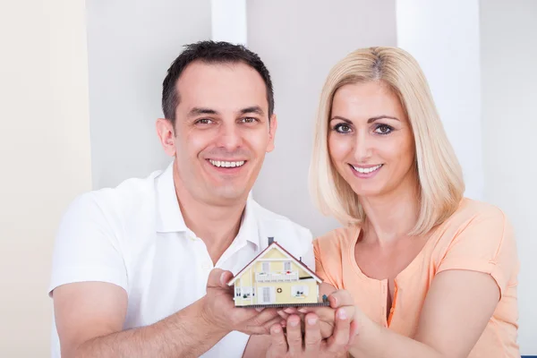 Paar houden huis model — Stockfoto