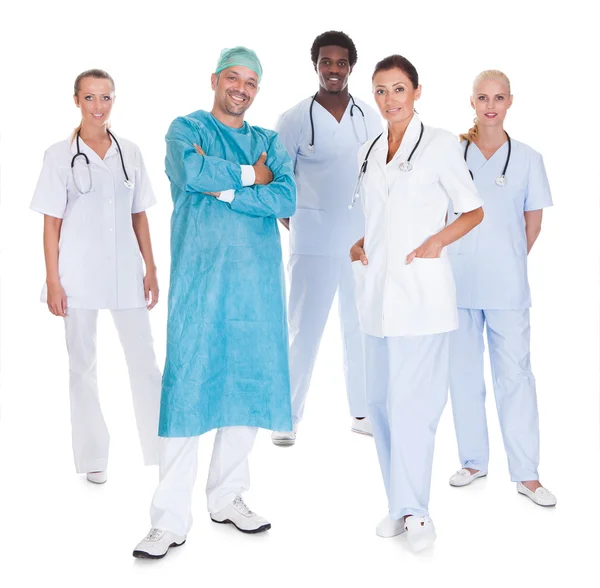 Счастливый доктор в хирургическом платье со своими коллегами — стоковое фото