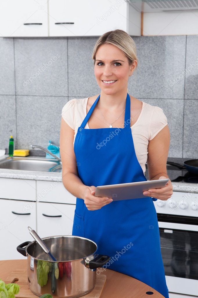 Woman Using Digital Tablet In Kitchen
