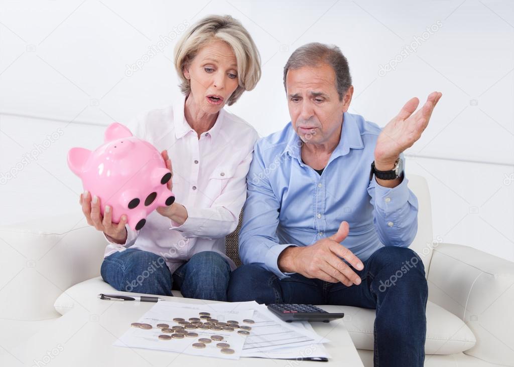 Shocked Couple Holding Piggybank