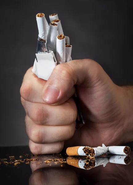 Punho de homem esmagando cigarros — Fotografia de Stock