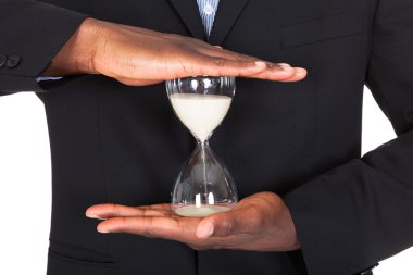 Businessman Holding Hourglass clipart