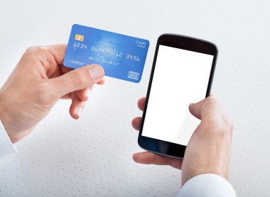 kredi kartı ve cep telefonu tutan adam