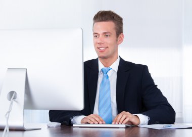 mutlu genç işadamı ofiste bilgisayar kullanma