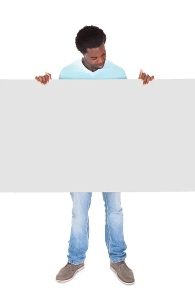 Ung man står bakom plakatet — Stockfoto