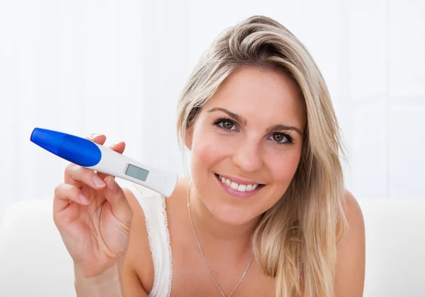 Mulher feliz olhando para teste de gravidez positivo — Fotografia de Stock