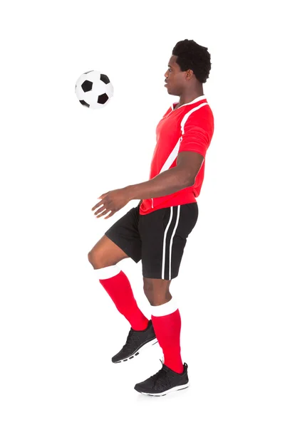 Jogador de futebol chutando futebol — Fotografia de Stock