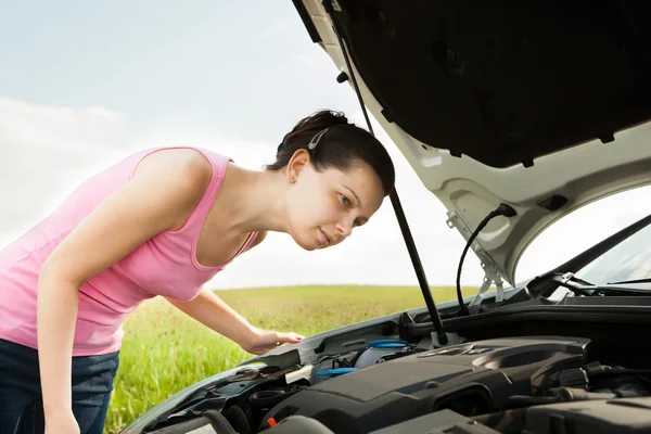 Donna guardando sotto il cofano auto — Foto Stock